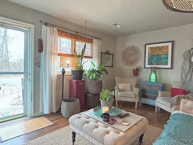 living area with visible vents and wood finished floors