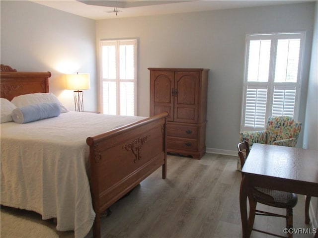 bedroom with light wood finished floors and baseboards