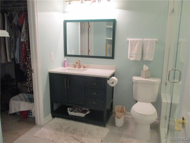 bathroom featuring vanity, a spacious closet, a shower with door, and toilet