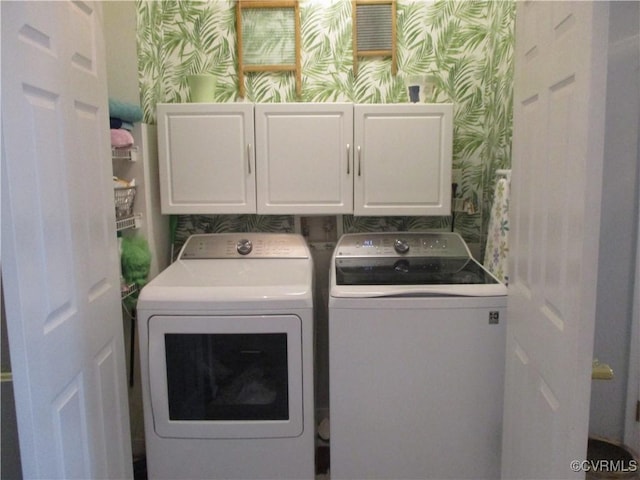 laundry room with independent washer and dryer, cabinet space, and wallpapered walls