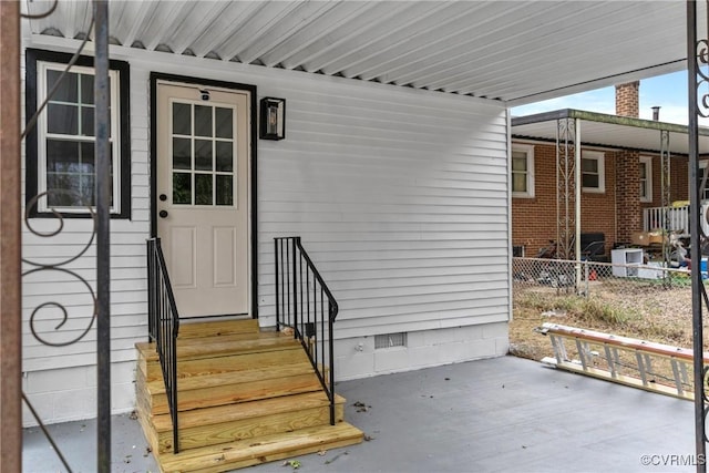 view of exterior entry featuring crawl space and fence