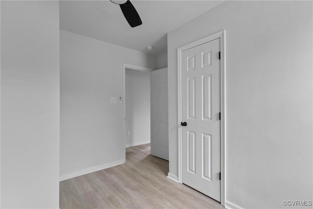 unfurnished bedroom with light wood-style flooring, baseboards, and a ceiling fan