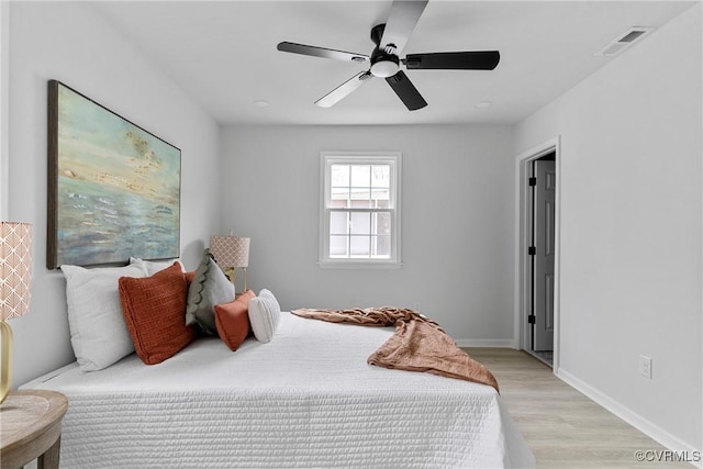 bedroom featuring visible vents, ceiling fan, light wood-style flooring, and baseboards