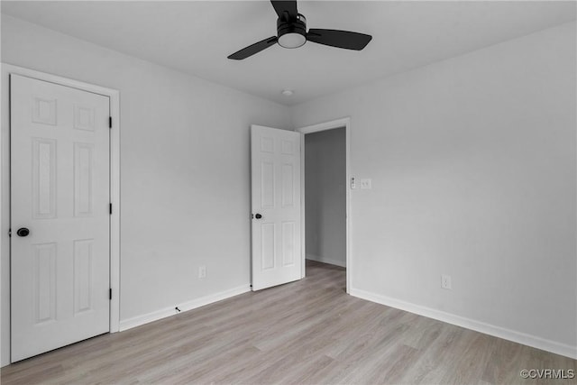 unfurnished bedroom with baseboards, a ceiling fan, and light wood-style floors