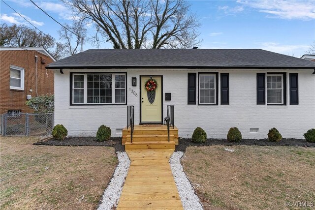 bungalow featuring brick siding, a shingled roof, fence, crawl space, and a front lawn