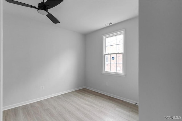 spare room with visible vents, ceiling fan, light wood-style flooring, and baseboards