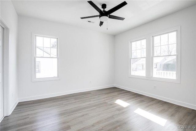 unfurnished room featuring visible vents, ceiling fan, baseboards, and wood finished floors