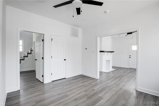 unfurnished room with visible vents, ceiling fan, and wood finished floors