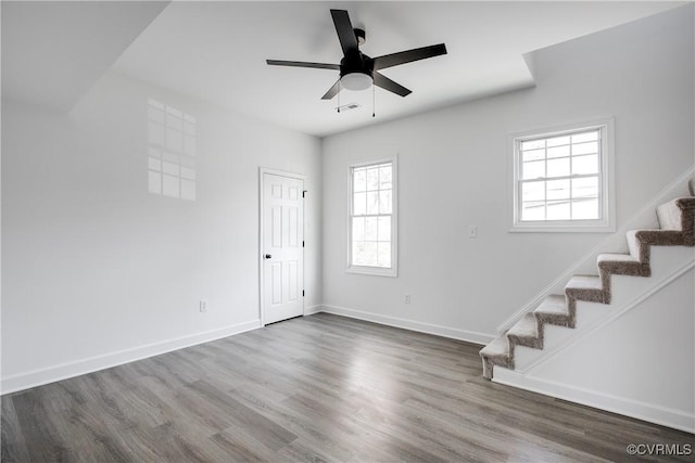 unfurnished room with stairway, baseboards, and wood finished floors