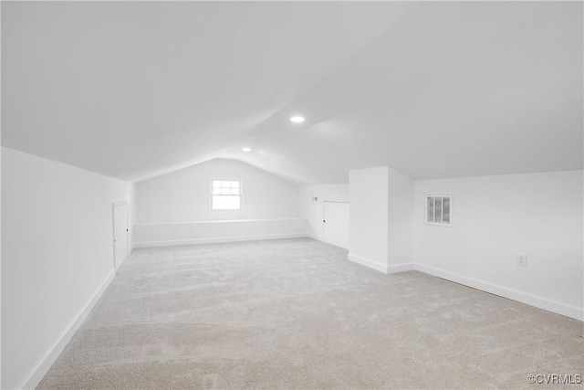 bonus room featuring baseboards, visible vents, vaulted ceiling, and carpet flooring