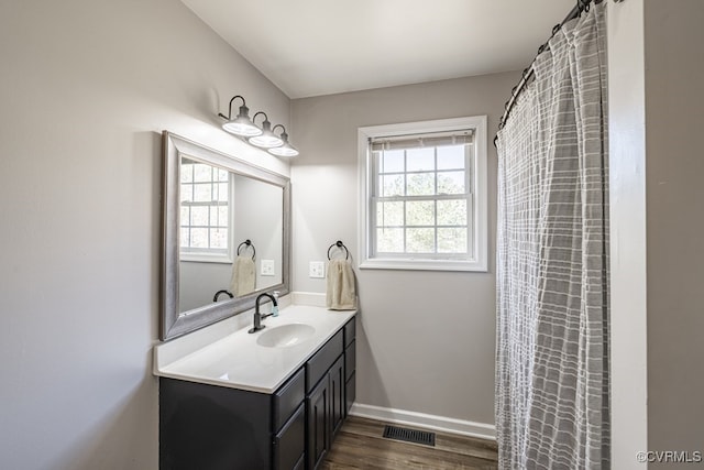 full bathroom with visible vents, baseboards, wood finished floors, and vanity