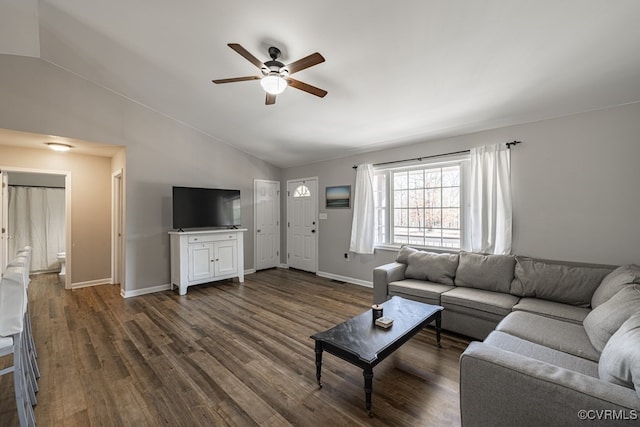 living area featuring dark wood-type flooring, vaulted ceiling, baseboards, and a ceiling fan