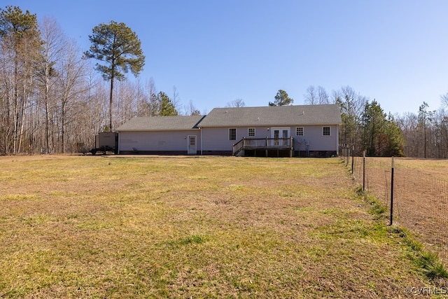 back of house with fence, a lawn, and a wooden deck