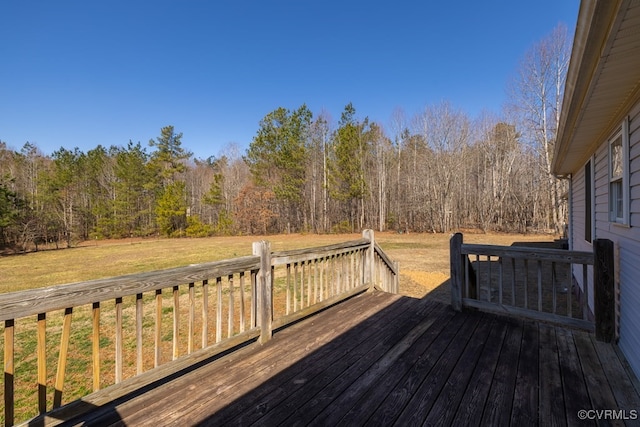 wooden deck with a yard and a forest view