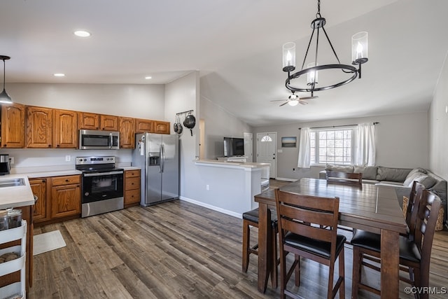 kitchen with open floor plan, stainless steel appliances, dark wood finished floors, and brown cabinets