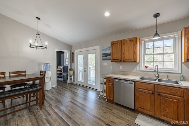 kitchen with brown cabinets, dark wood finished floors, vaulted ceiling, a sink, and dishwasher