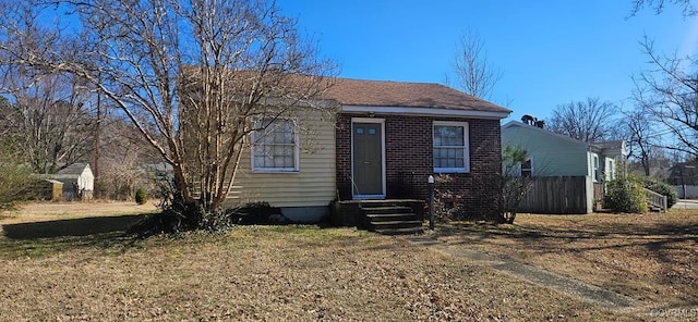 view of front of home with brick siding and a front lawn