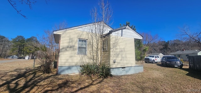 view of side of property featuring crawl space and a yard