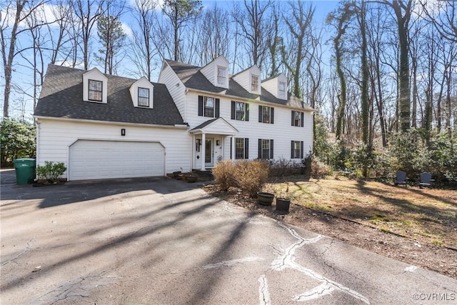 view of front of property with a garage, aphalt driveway, and roof with shingles