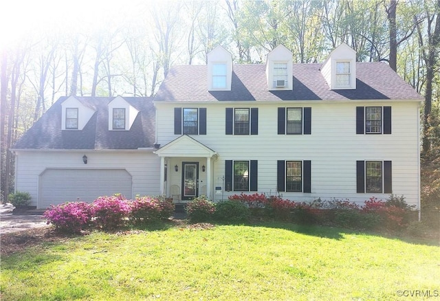 view of front of home featuring an attached garage, roof with shingles, and a front yard