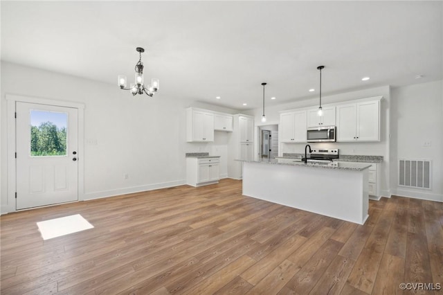 kitchen with white cabinetry, visible vents, light wood finished floors, and stainless steel appliances