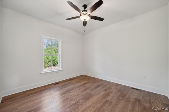 spare room with visible vents, baseboards, and hardwood / wood-style flooring