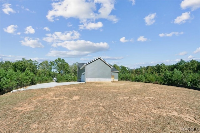 view of yard featuring an outbuilding, driveway, and a garage