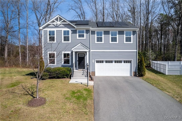 view of front facade featuring solar panels, fence, aphalt driveway, a front yard, and a garage