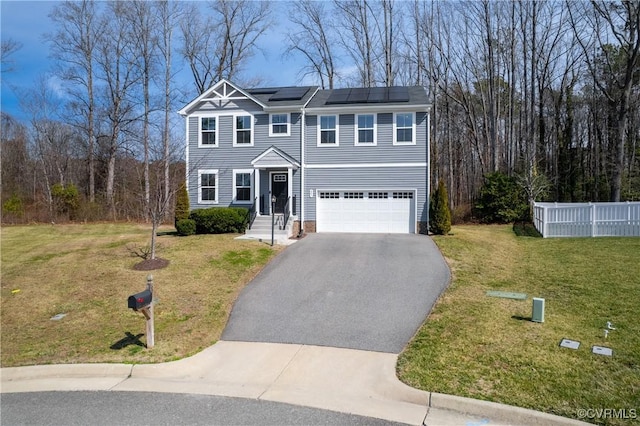 view of front of house featuring solar panels, a front lawn, fence, a garage, and driveway