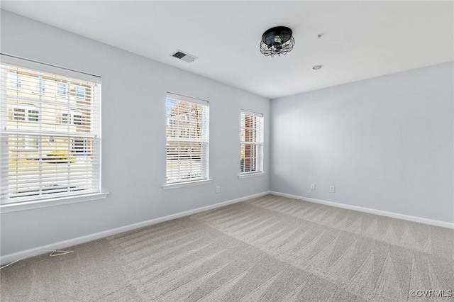 carpeted empty room featuring visible vents and baseboards