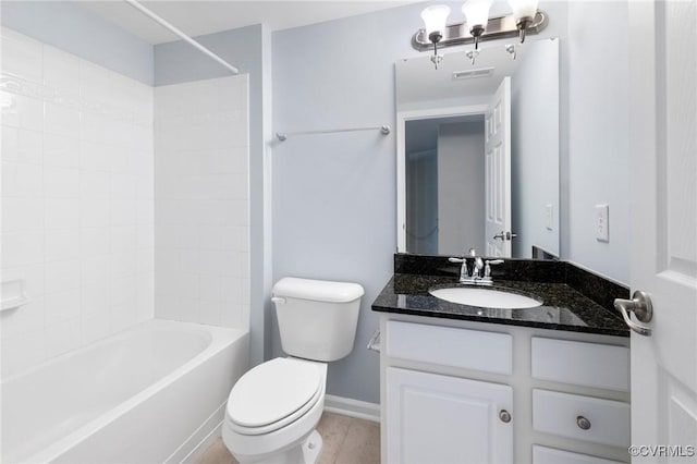 bathroom with bathing tub / shower combination, baseboards, toilet, and vanity