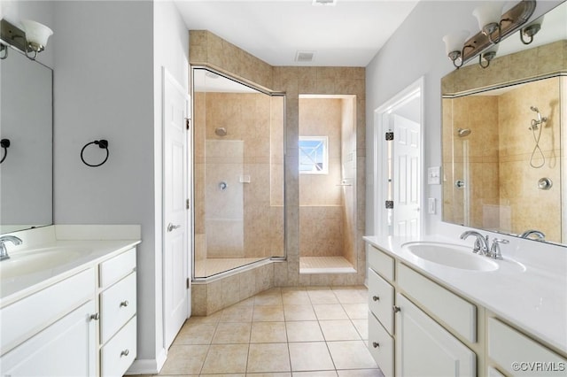 bathroom featuring tile patterned flooring, visible vents, a shower stall, and a sink