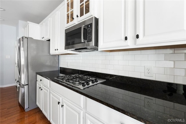 kitchen with dark countertops, white cabinets, and appliances with stainless steel finishes