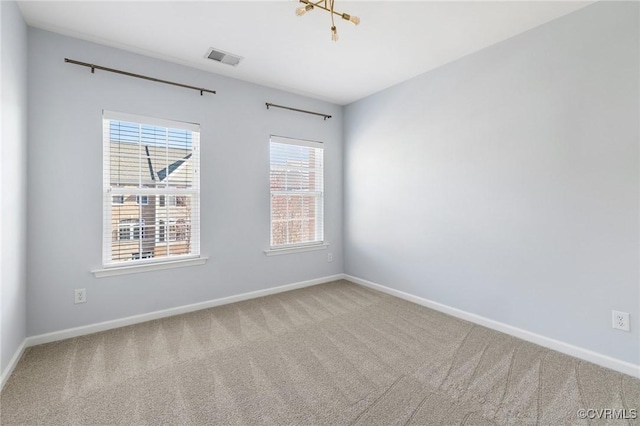 unfurnished room featuring carpet, visible vents, and baseboards