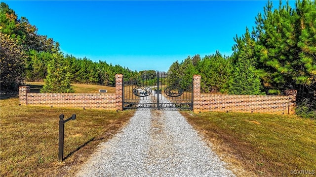 view of gate with a lawn