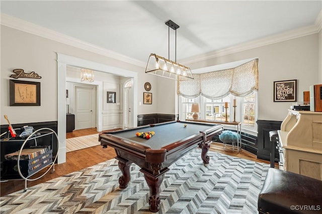 game room with wood finished floors, wainscoting, and ornamental molding