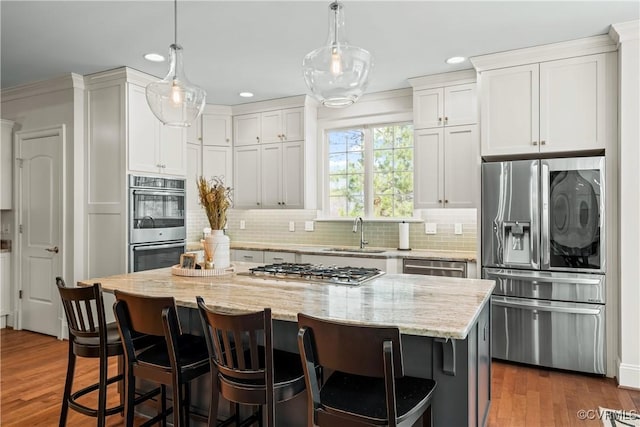 kitchen with a sink, dark wood-type flooring, appliances with stainless steel finishes, and white cabinets