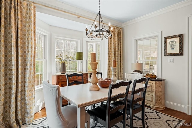 dining room featuring baseboards, crown molding, an inviting chandelier, and wood finished floors