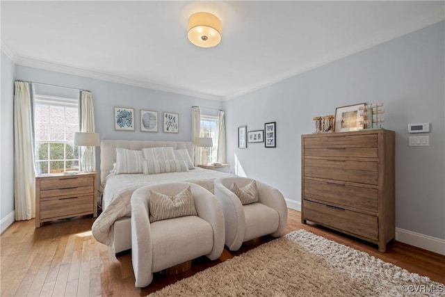 bedroom with multiple windows, wood finished floors, and baseboards