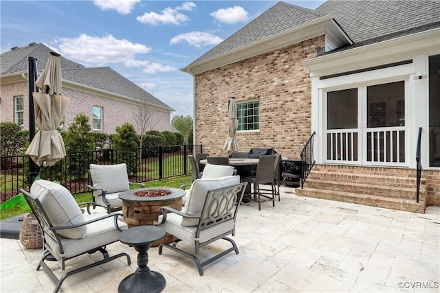 view of patio with a fire pit, outdoor dining space, entry steps, and fence