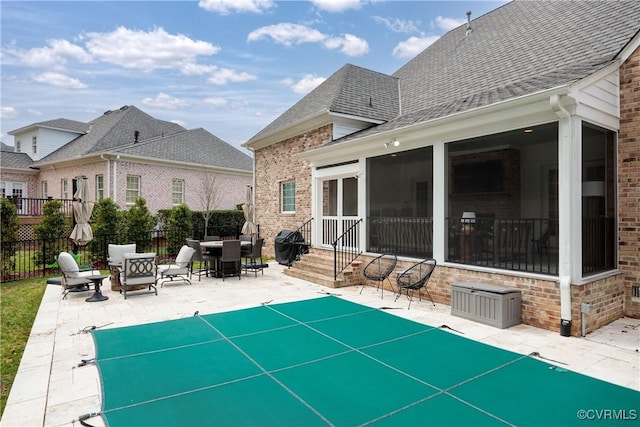 view of patio / terrace featuring entry steps, fence, a grill, a sunroom, and a fenced in pool