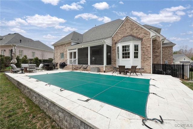 view of pool with a fenced in pool, fence, a patio, and a sunroom