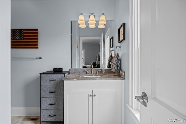 ensuite bathroom with visible vents, baseboards, connected bathroom, and vanity