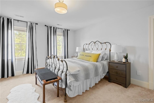 bedroom with visible vents, baseboards, and light colored carpet