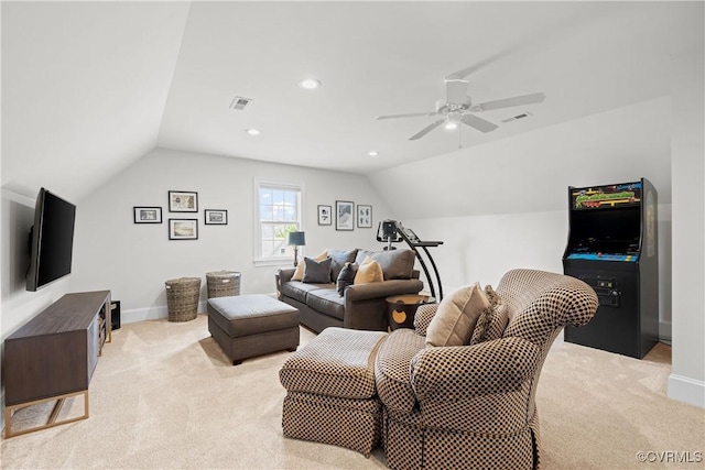 living room with a ceiling fan, vaulted ceiling, light colored carpet, and visible vents