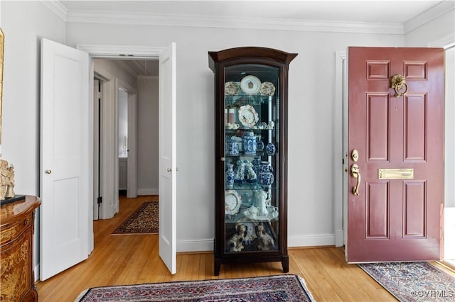 entrance foyer with baseboards, light wood-type flooring, and ornamental molding