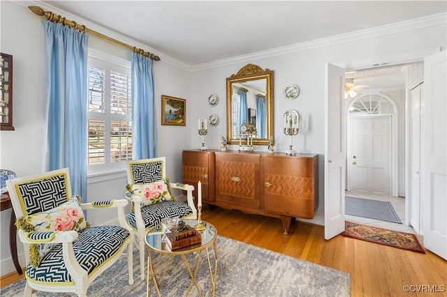 sitting room with wood finished floors and ornamental molding