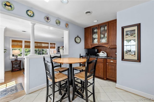 dining space featuring light tile patterned floors, visible vents, and ornate columns