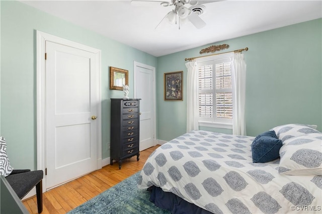 bedroom featuring light wood finished floors, baseboards, and a ceiling fan