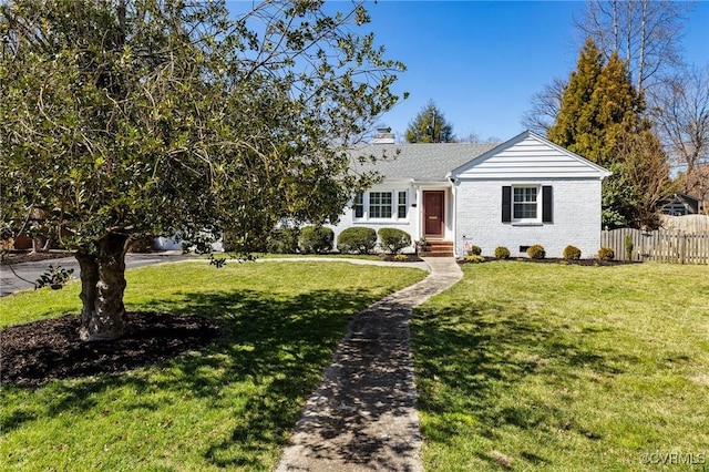 view of front of house featuring a front yard, fence, brick siding, and a chimney